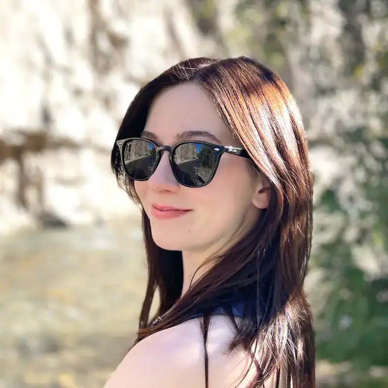 woman wearing sunglasses, smiling.